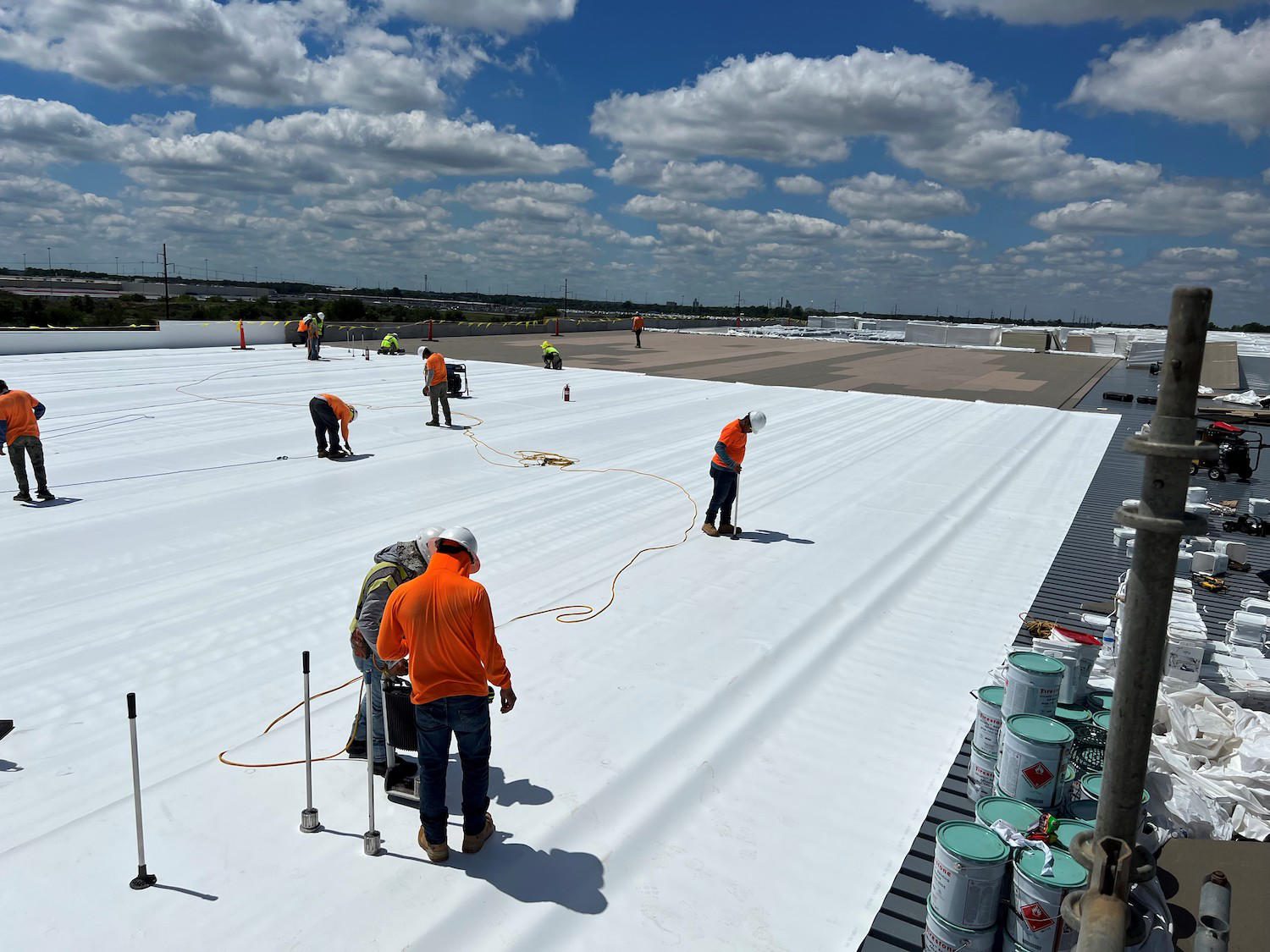 Crew rolling out membrane on a commercial roofing St Louis flat roof